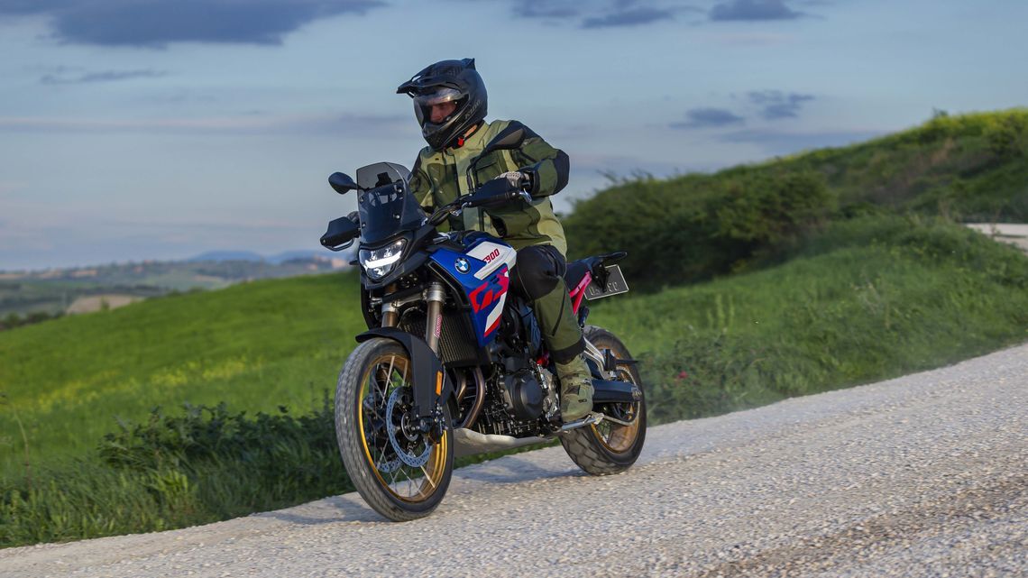 Un motociclista en una moto BMW de aventura recorriendo un camino de tierra con llantas MICHELIN Anakee Adventure 2.