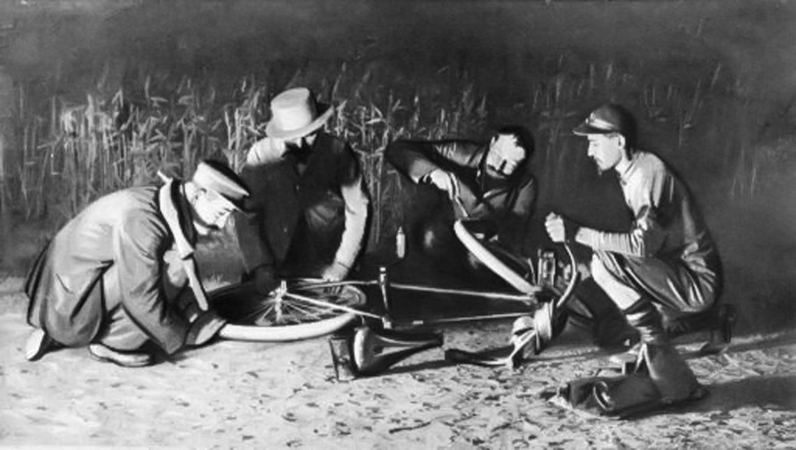 パリ-クレルモンフェランのレースでタイヤを修復しているエドアール・ミシュラン（中央）