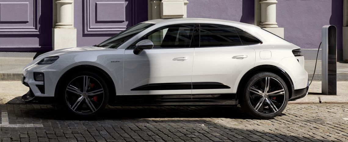 Porsche Macan Turbo EV สีขาวกำลังจอดชาร์จไฟฟ้า