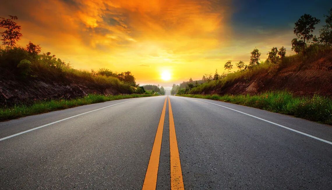 夕焼けに向かい真っ直ぐ伸びる道路