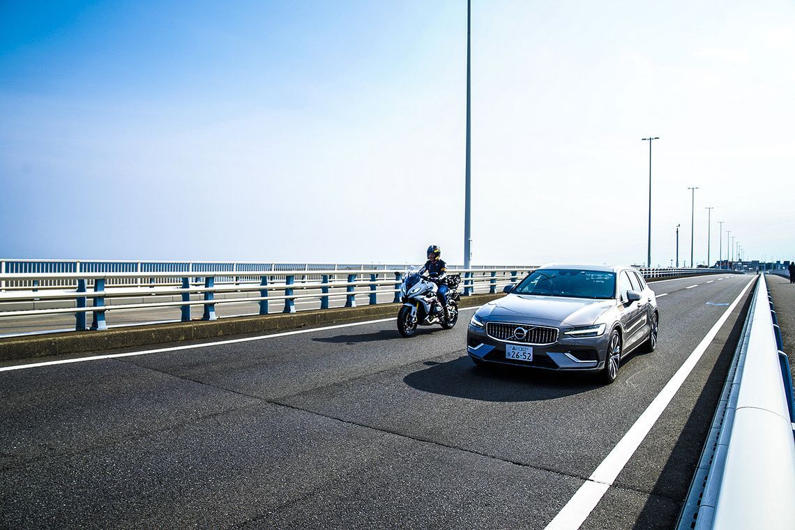海沿いを走るBMW R 1250 RSとVOLVO V60 Recharge Plug-in hybrid T6 AWD Inscription