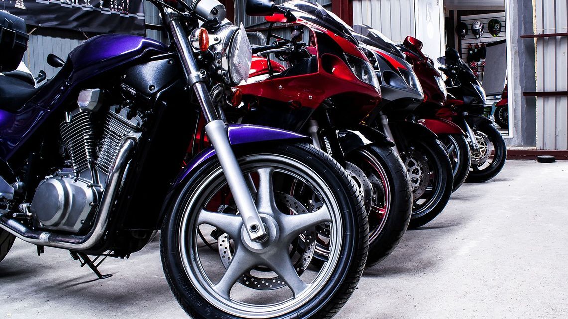 Several motorcycles lined up in a row, showcasing different colors and styles.