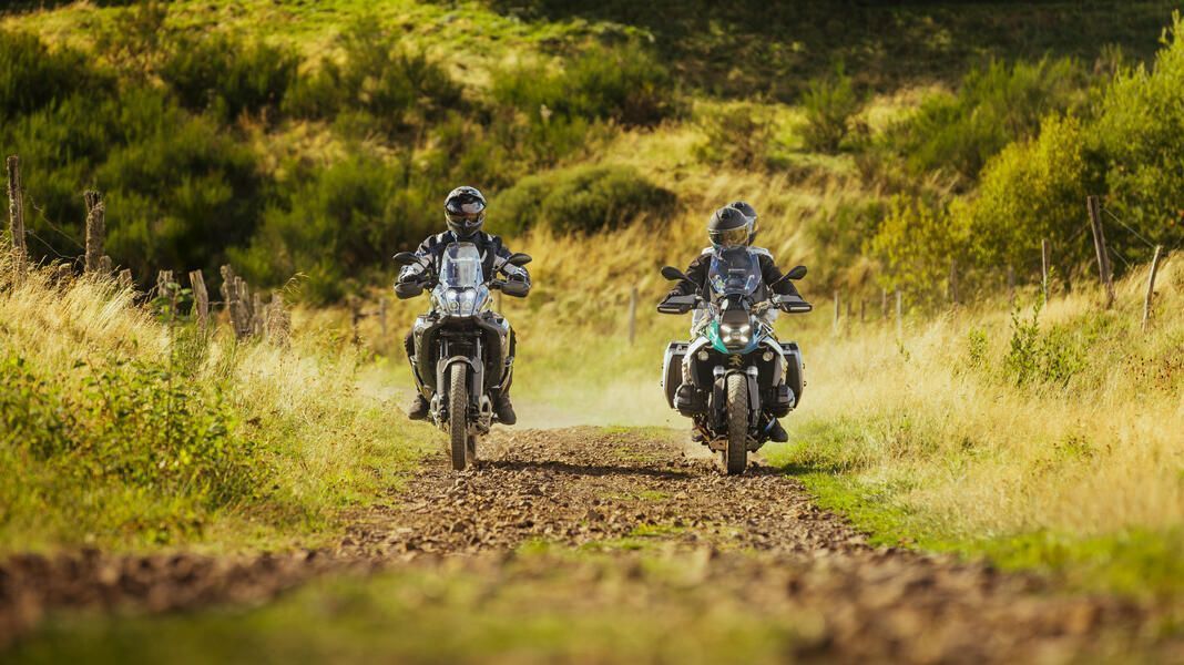 Pneus MICHELIN Anakee Adventure 2 em utilização: duas motos de aventura a percorrer um trilho rochoso fora de estrada, com um fundo natural desfocado.