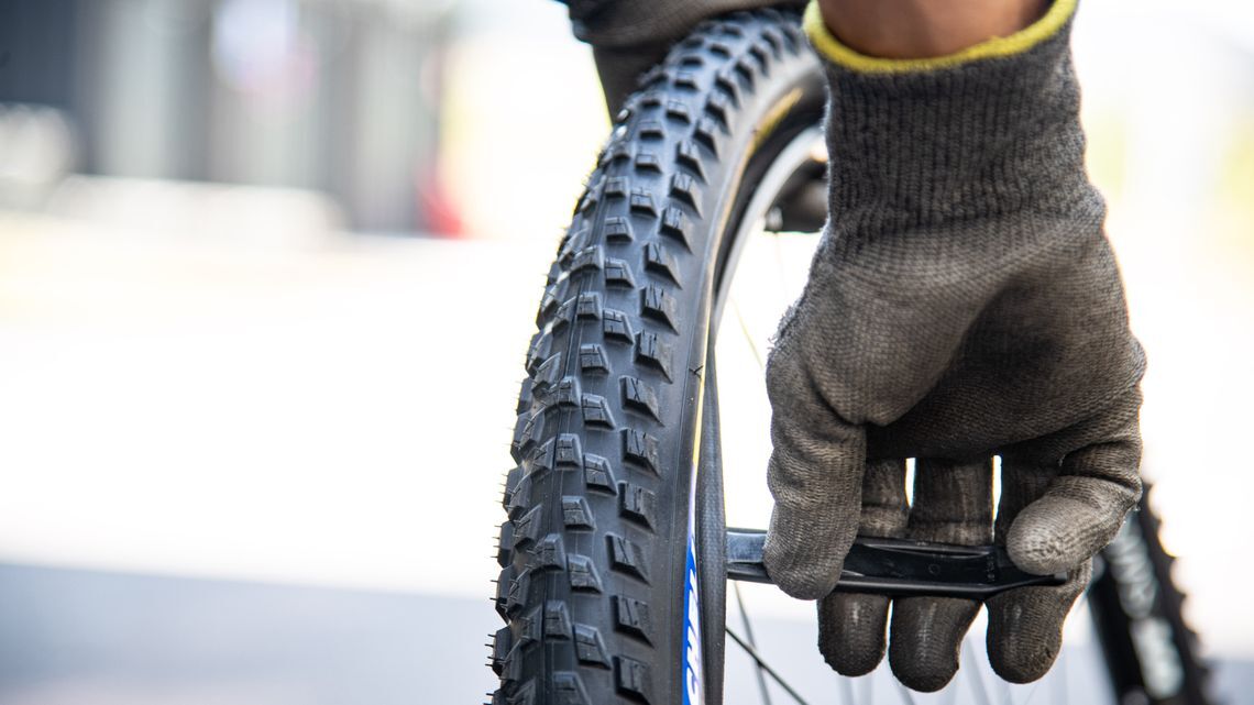 Setze vorsichtig einen Reifenhebel auf jeder Seite des Ventils