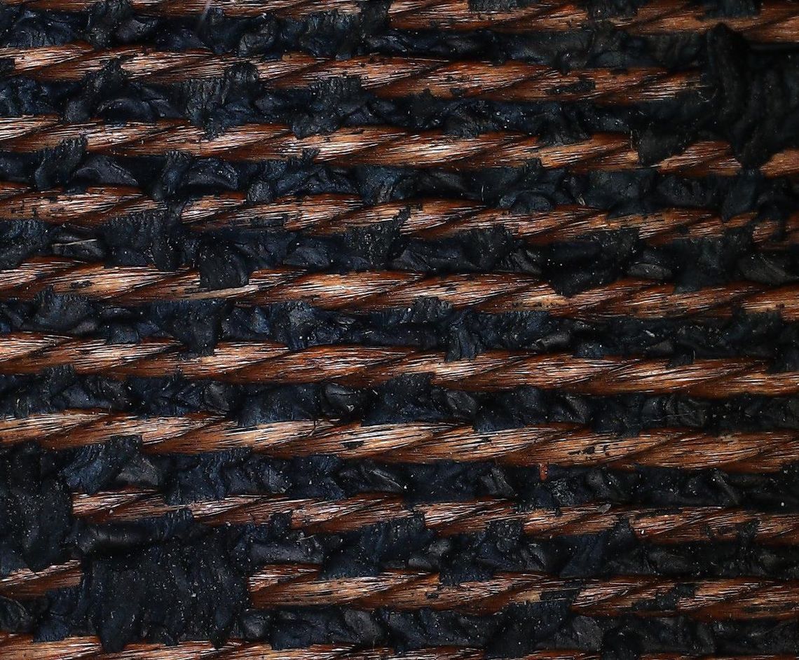 Microscopic image of nylon textile reinforcement bonded to tire rubber using formaldehyde-free ResiCare resin.