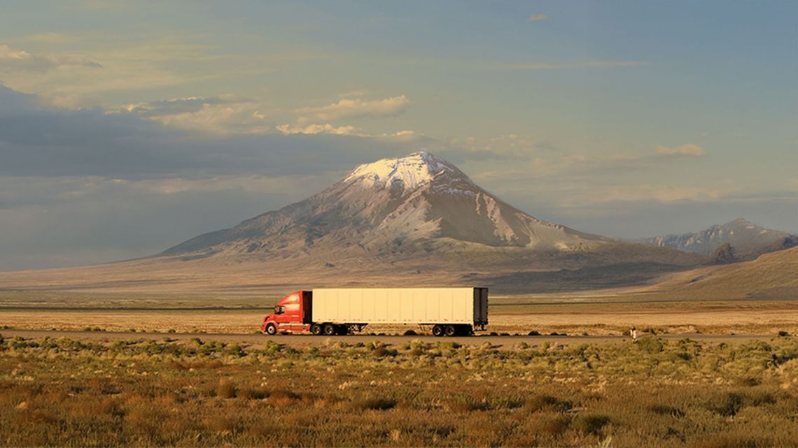Image of semi-truck with BFGoodrich tires driving across scenic desert highway.