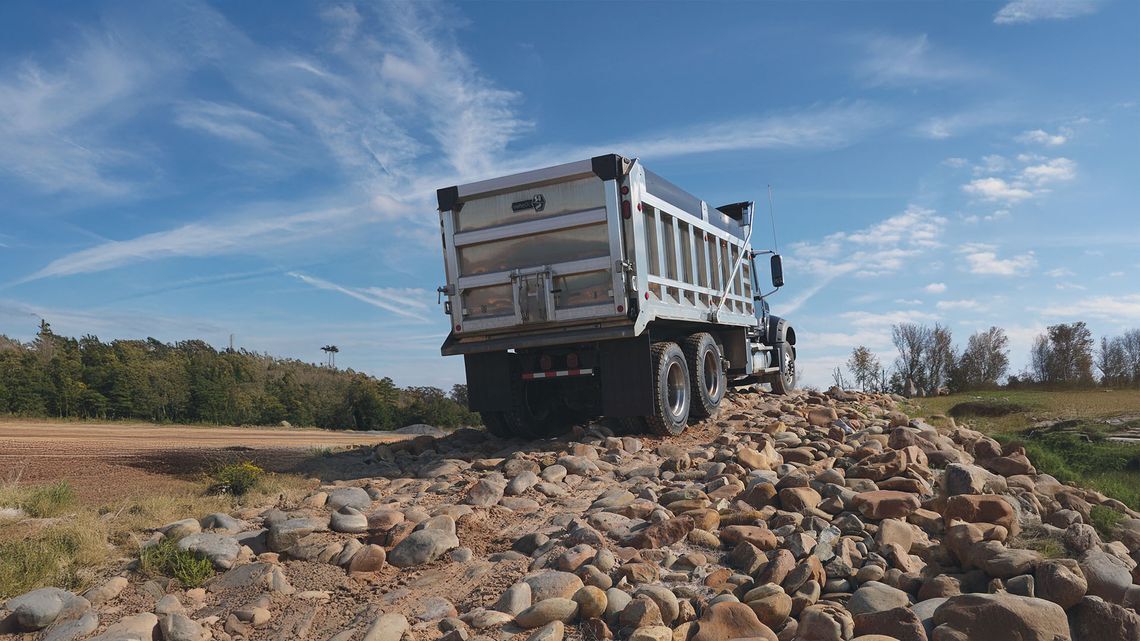 Image of dump truck going over rocky terrain