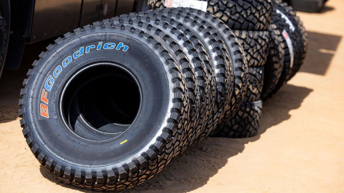 Hiekkaiselle maalle pinottu kasa BFGoodrich-renkaita, jotka ovat valmiina käytettäväksi Dakar-rallissa