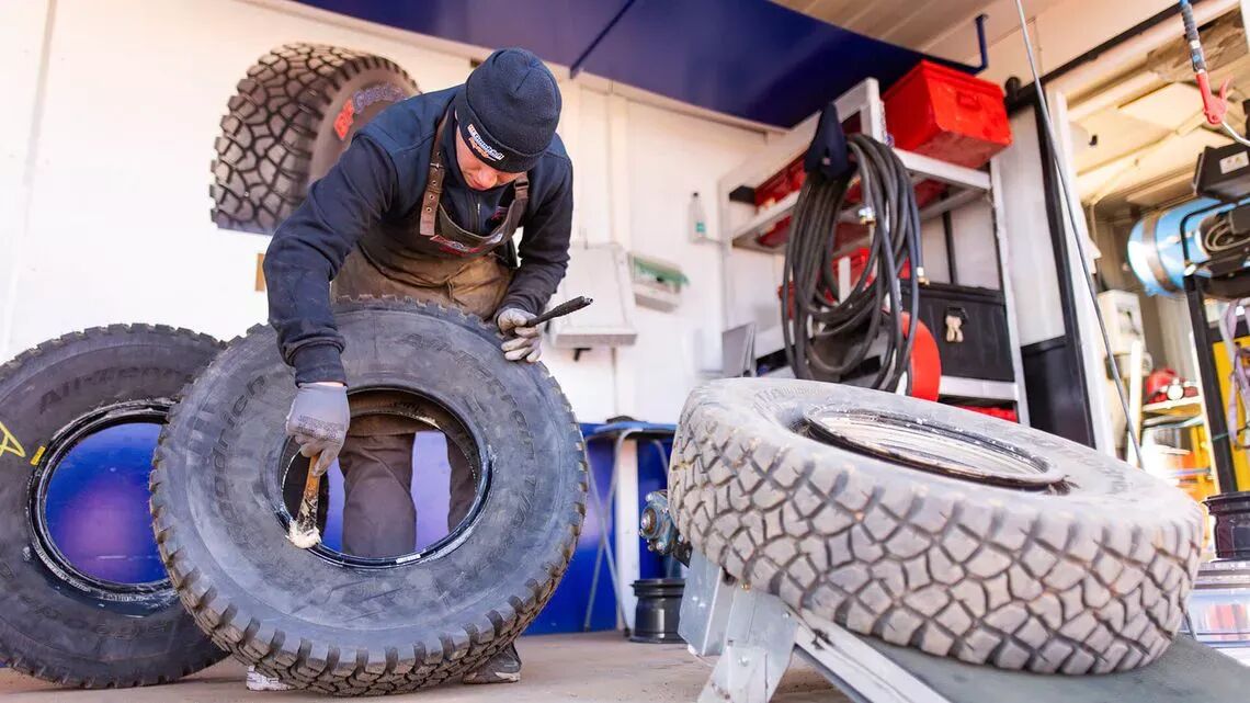"Mekaniker reparerar terrängfordonsdäck i en verkstad, använder specialistverktyg och utrustning "