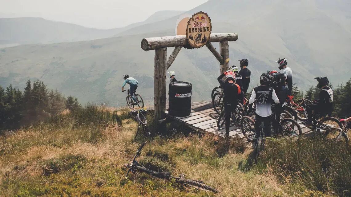 Red Bull Hardline mountainbikecyklister redo att ta sig nedför en brant led i ett bergigt landskap